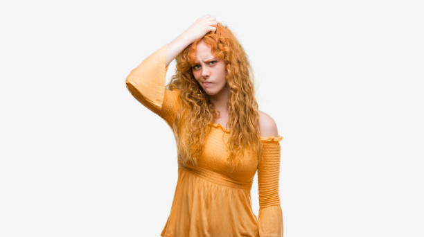istock Young redhead woman confuse and wonder about question. Uncertain with doubt, thinking with hand on head. Pensive concept. 1053147968