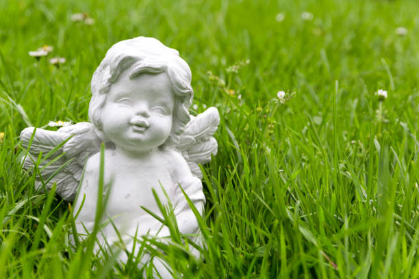 white angel statue in front of a church in the park