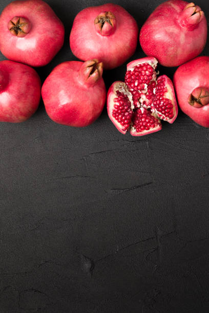 istock Ripe red pomegranate closeup photography on black background with copy space. 1053161184