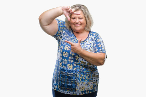 istock Senior plus size caucasian woman over isolated background smiling making frame with hands and fingers with happy face. Creativity and photography concept. 1053161214
