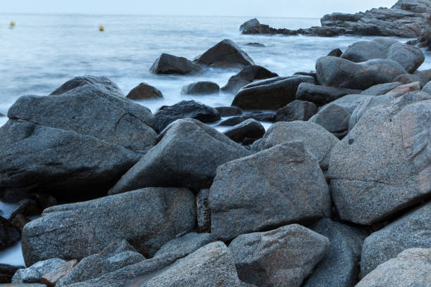 istock sea waves and surf hitting and splashing rocks 1053165728