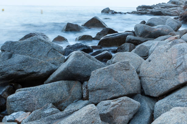 istock sea waves and surf hitting and splashing rocks 1053165848
