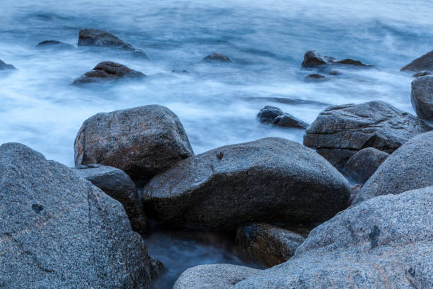 istock sea waves and surf hitting and splashing rocks 1053165856