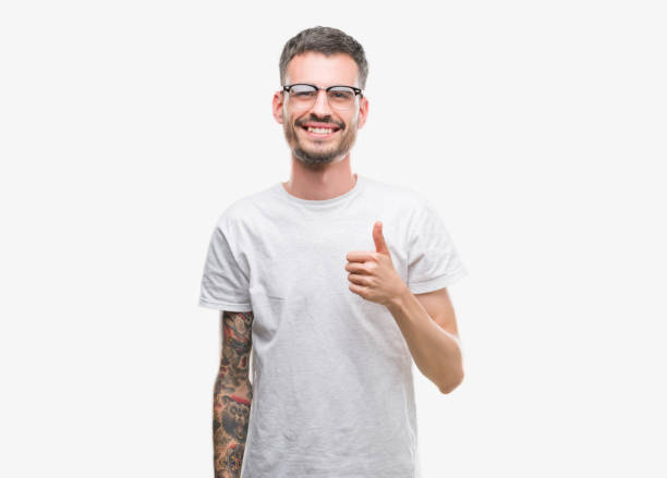 istock Young tattooed adult man doing happy thumbs up gesture with hand. Approving expression looking at the camera with showing success. 1053170570