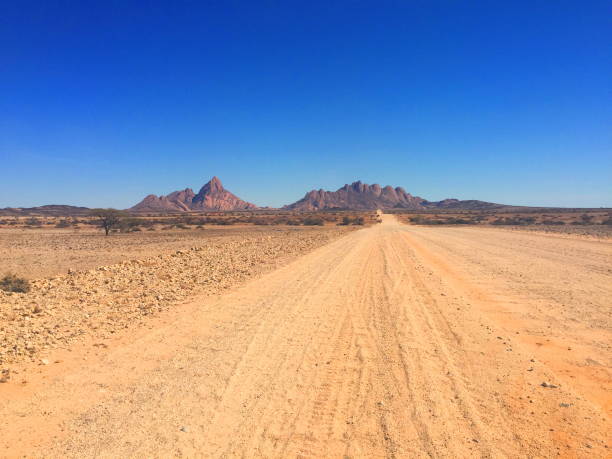 strada sterrata vuota per la montagna namibia - dirt road road desert road gravel foto e immagini stock