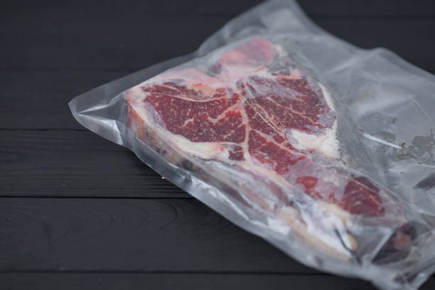 istock Vacuum packed meat on old wooden background. 1053174092