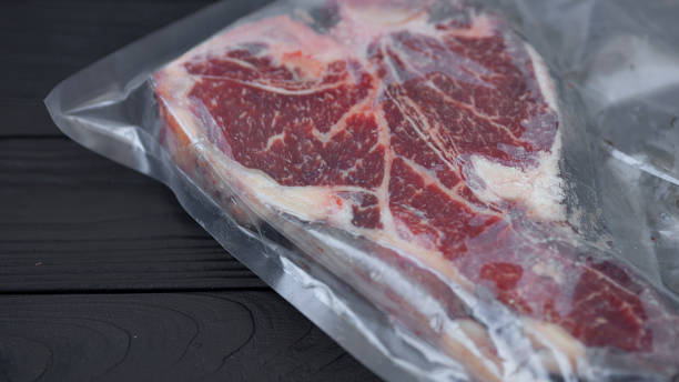 istock Vacuum packed meat on old wooden background. 1053174098