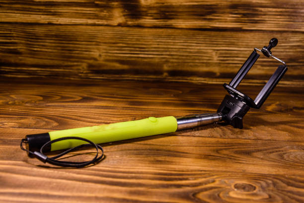 istock Selfie stick with adjustable clamp on a wooden table 1053183912