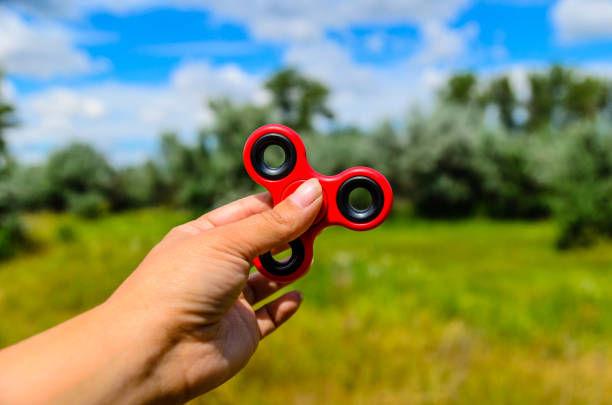istock Red fidget spinner in female hand 1053183958