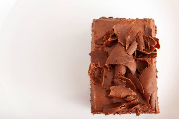 istock A piece of chocolate cake with shavings on a plate on a white background with copy space 1053186096