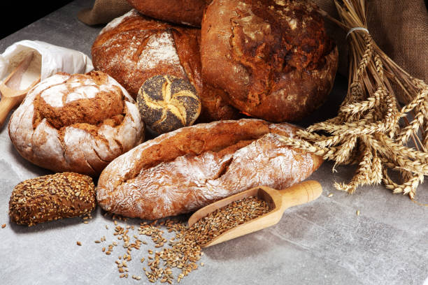 istock Different kinds of bread and bread rolls on board from above. Kitchen or bakery 1053190580
