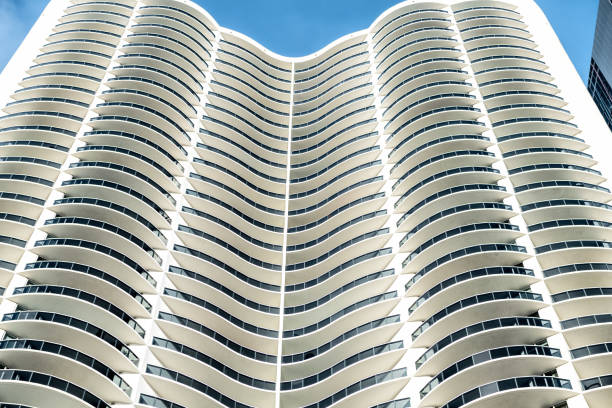 Abstract view on residential, apartment complex building with many windows, balconies painted in white during sunny day