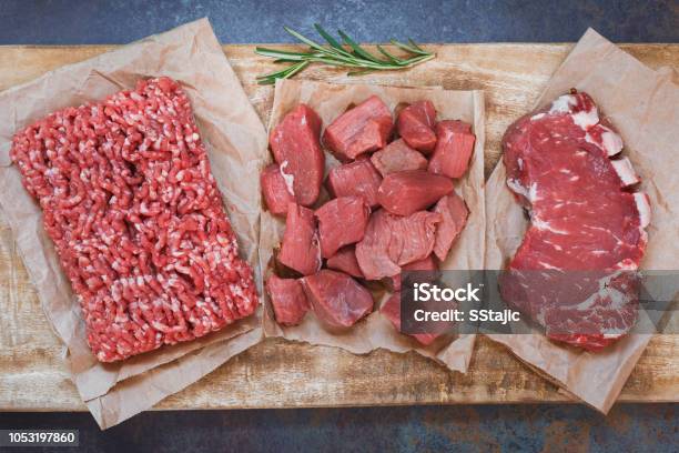 Fresh Raw Angus Beef Meat Whole Ground And Chopped On Parchment Paper Stock Photo - Download Image Now