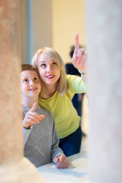 Young mother and son exploring old bas-reliefs in museum