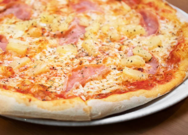 istock Crispy hot pizza with ham and pineapples. 1053202510