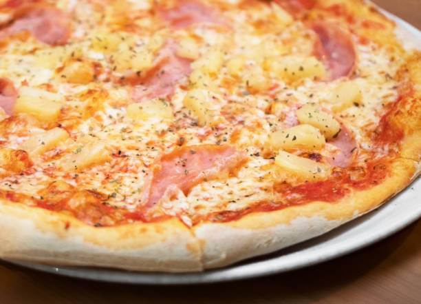 Crispy hot pizza with ham and pineapples. stock photo