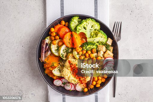 istock Vegan Buddha bowl with baked vegetables, chickpeas, hummus and tofu, top view. 1053206576