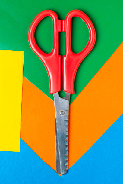 istock Scissors lie on multicolor paper. Green, Orange, Yellow, Blue 1053208252