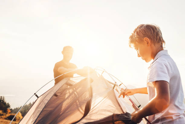 istock Father and son install touristic tent for camping 1053208672