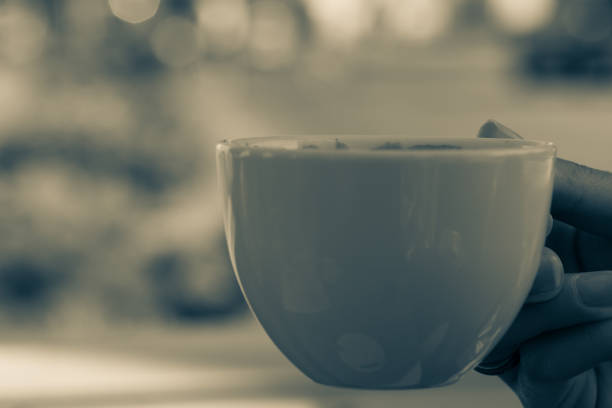 istock Woman's hand holding small coffee mug 1053223364