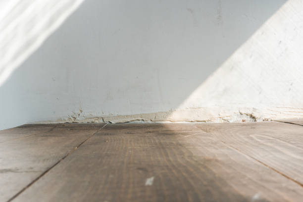 istock wooden floor background and white wall closeup 1053225400