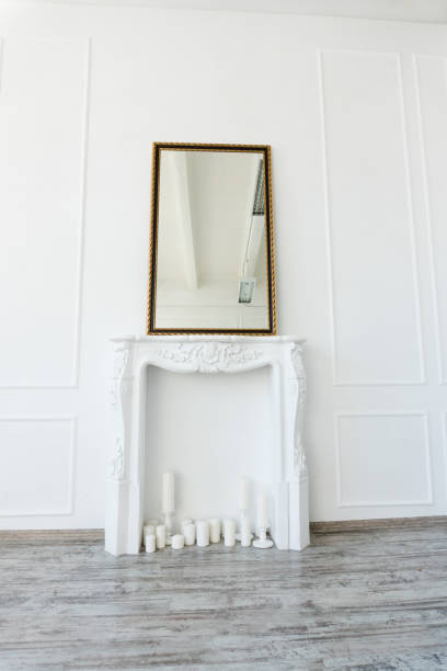 istock white fireplace with a mirror above it in an empty room 1053226918