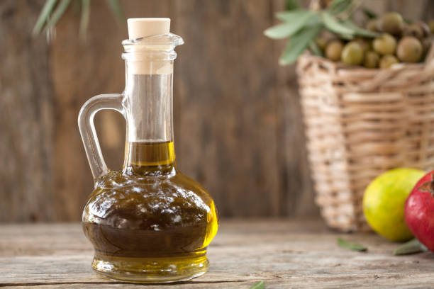 istock olive oil bottle over wooden table 1053229180