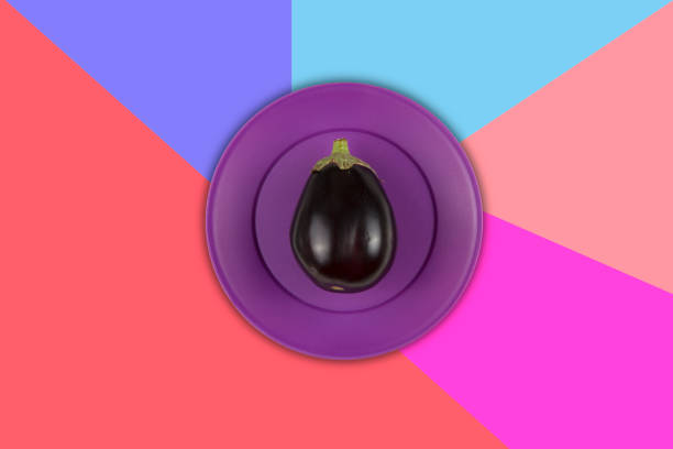 Fresh organic eggplant in Purple plastic Plate on multicolored pop art Background .Vitamins Healthy Diet Spring Summer Detox Vegan. Ready to write.Poster Banner Template.
