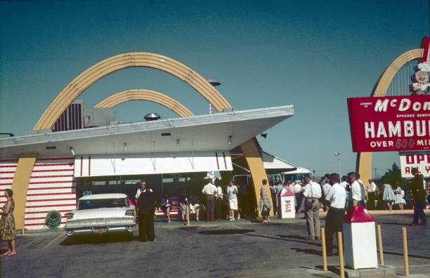 Detroit, Michigan, USA, 1962. McDonald's store in Detroit. Furthermore: visitors, consumers, advertising sign and a parking lot with cars.