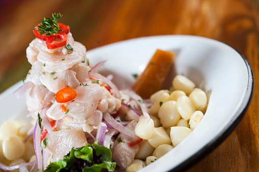 Ceviche, dish symbol of Peruvian gastronomy. On a wooden table.