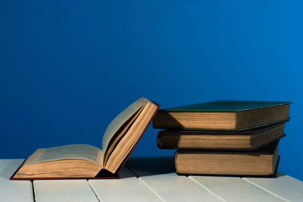 istock One open old book books wooden table. Beautiful background. 1053236650