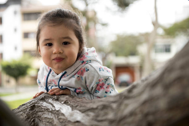 istock Little girl hugging a tree, looking up 1053239220