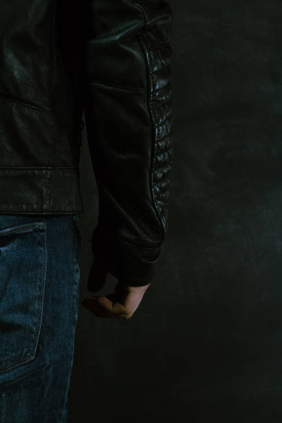 istock Young guy with a knife about to attack, over dark background.Young guy with a knife about to attack, over dark background. 1053239608