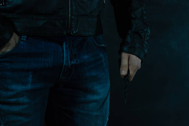 istock Young guy with a knife about to attack, over dark background. 1053239668