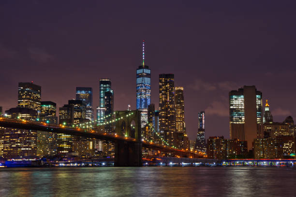 New York Manhattan skyline and Brooklyn Bridge by night stock photo