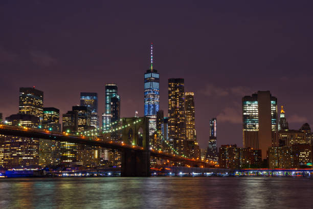 new york manhattan skyline and brooklyn bridge by night - new york city new york state skyline city imagens e fotografias de stock