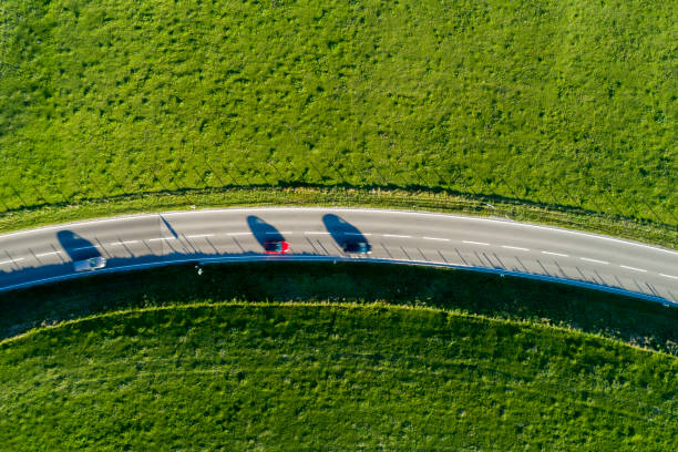 istock Aerial View of Road Between Green Fields 1053255810