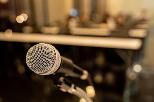 istock Microphone over the blurred business forum Meeting or Conference Training Learning Coaching Room Concept with noise, Blurred background. 1053256602