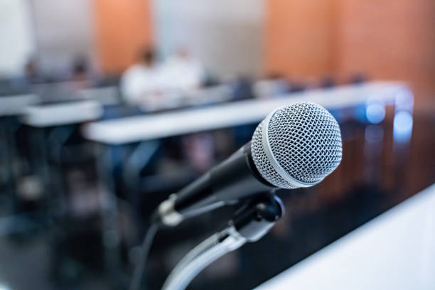 istock Microphone over the blurred business forum Meeting or Conference Training Learning Coaching Room Concept with noise, Blurred background. 1053256604