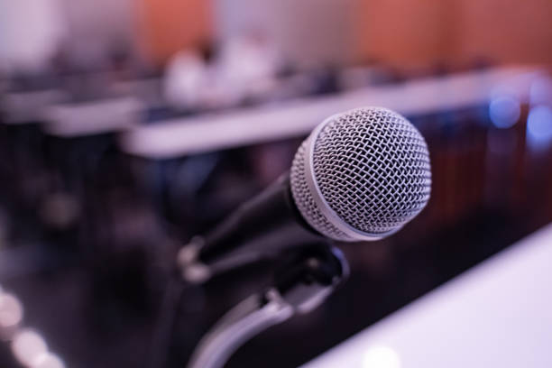 istock Microphone over the blurred business forum Meeting or Conference Training Learning Coaching Room Concept with noise, Blurred background. 1053256608