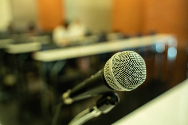 istock Microphone over the blurred business forum Meeting or Conference Training Learning Coaching Room Concept with noise, Blurred background. 1053256612