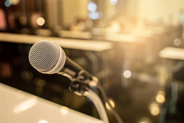 istock Microphone over the blurred business forum Meeting or Conference Training Learning Coaching Room Concept with noise, Blurred background. 1053256614