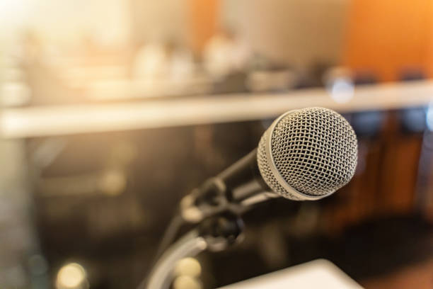 istock Microphone over the blurred business forum Meeting or Conference Training Learning Coaching Room Concept with noise, Blurred background. 1053256618