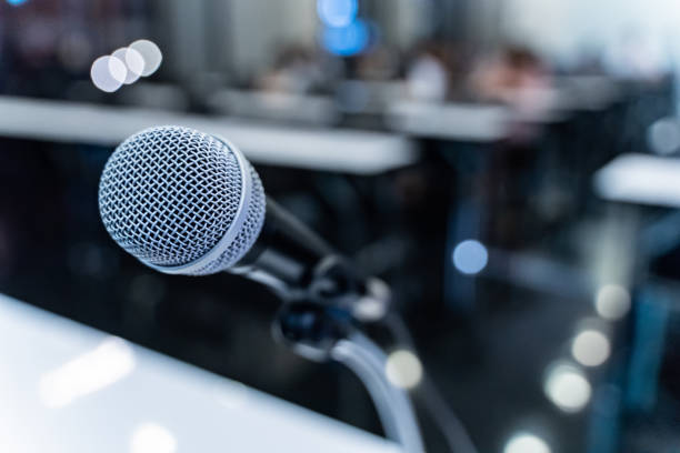 istock Microphone over the blurred business forum Meeting or Conference Training Learning Coaching Room Concept with noise, Blurred background. 1053256624