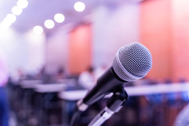 istock Microphone over the blurred business forum Meeting or Conference Training Learning Coaching Room Concept with noise, Blurred background. 1053256632