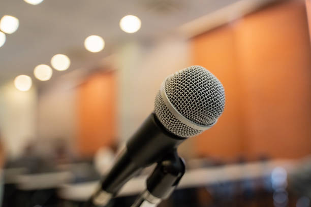 istock Microphone over the blurred business forum Meeting or Conference Training Learning Coaching Room Concept with noise, Blurred background. 1053256656