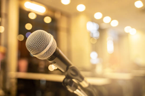 istock Microphone over the blurred business forum Meeting or Conference Training Learning Coaching Room Concept with noise, Blurred background. 1053256672