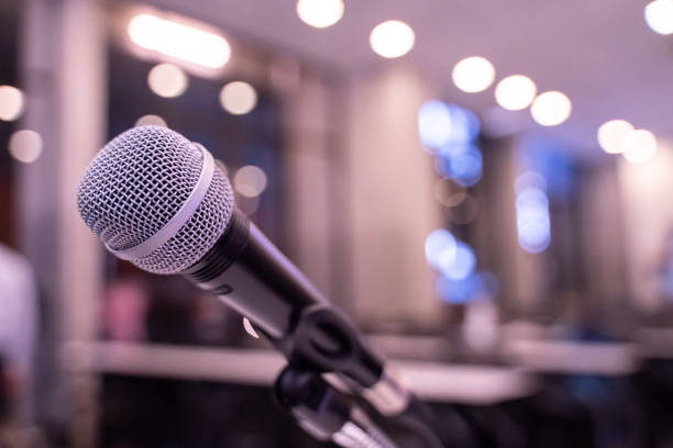 istock Microphone over the blurred business forum Meeting or Conference Training Learning Coaching Room Concept with noise, Blurred background. 1053256676