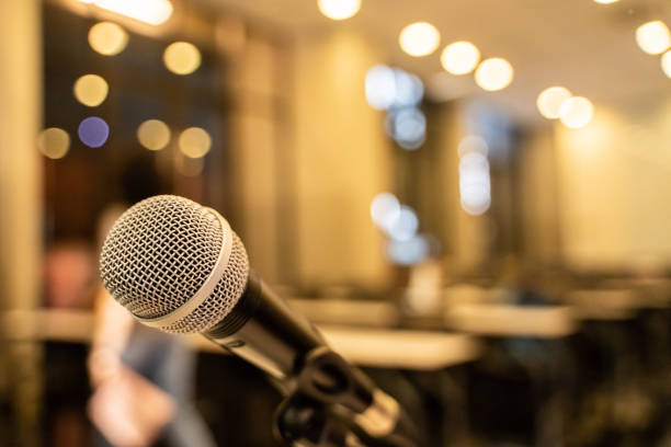 istock Microphone over the blurred business forum Meeting or Conference Training Learning Coaching Room Concept with noise, Blurred background. 1053256680