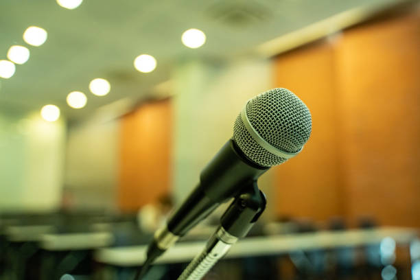 istock Microphone over the blurred business forum Meeting or Conference Training Learning Coaching Room Concept with noise, Blurred background. 1053256688